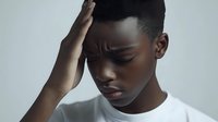 Young African American man experiencing headache holding head with hand expressing pain and stress on neutral background.