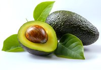 Fresh ripe avocado cut in half showing creamy yellow flesh and brown pit with green leaves isolated on white background for healthy cooking designs.