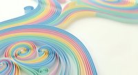 Colorful rainbow paper quilling art with flowing spiral patterns and curved lines on white background for creative design projects.