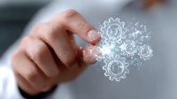 Finger touching glowing digital gears with sparkle effect on blurred background, representing business automation and technological innovation process.