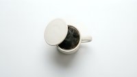 Overhead view of white ceramic mug filled with dark coffee or tea, isolated on white background, ready for beverage mockup designs and product presentations.