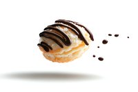 Levitating vanilla cream puff pastry drizzled with dark chocolate sauce on white background, floating dessert with chocolate drops isolated for design.