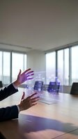 Businessman hands interacting with futuristic holographic interface displaying data analytics in modern office conference room for presentations.