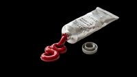 Tube of red paint or gel squeezing out with metallic cap on transparent background, ready for design use on t-shirts, stickers, clipart, print-on-demand products, and sublimation projects.