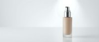 Beige foundation bottle with silver pump dispenser on clean white background for cosmetic product photography and beauty brand marketing materials.