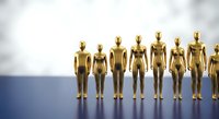 Golden metallic human figures standing in row on blue surface against white background representing teamwork, leadership and business concepts.