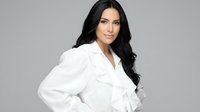 Young woman with long black hair and olive complexion wearing white blazer against neutral background, suitable for corporate and professional design projects.