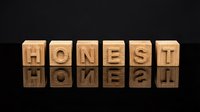 Wooden letter blocks spelling HONEST with mirror reflection on dark surface. Business ethics, integrity and trust concept for corporate presentations.