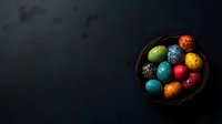 Colorful decorated Easter eggs in wooden bowl on dark background with copy space for holiday greeting cards and seasonal marketing materials.