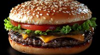 Appetizing cheeseburger with melted cheese, fresh vegetables and sesame seed bun photographed on black background with dramatic lighting and sharp details.