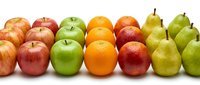 Fresh colorful fruits arranged in rows including red and green apples, oranges and pears on white background for healthy eating and nutrition concepts.