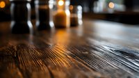 Rustic wooden table surface with warm bokeh lights in dark restaurant setting, showing natural wood grain texture and atmospheric evening ambiance.