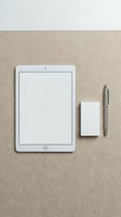 White tablet with blank screen, business card and pen on beige textured surface. Minimalist workspace mockup for digital presentations and branding.