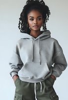 Young African American woman with natural curly hair wearing casual grey hoodie and cargo pants against light background, modern urban style portrait.