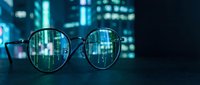 Digital data streams reflected in eyeglasses with futuristic cyber technology background for business analytics and information visualization concepts.