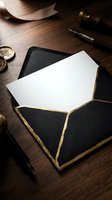 Elegant black envelope with gold trim containing blank white card on wooden desk with vintage wax seal stamps and fountain pen for luxury correspondence.