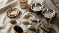 Luxury pet accessories collection featuring modern food bowls, toys and grooming brush in neutral tones for stylish dog and cat care essentials.
