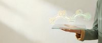 Man in green sleeve holding tablet with financial icons floating above screen for business technology and digital banking concepts.