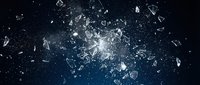 Shattered glass fragments exploding with bright light burst against dark blue background creating dramatic destruction effect for design projects.