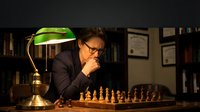 Thoughtful businessman in suit contemplating chess strategy under vintage banker lamp in classic office library setting with books and diplomas.