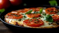 Fresh margherita pizza with melted mozzarella, sliced tomatoes and basil leaves on dark background, close up view of traditional Italian cuisine.