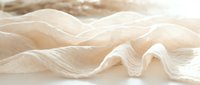Flowing cream-colored fabric with soft waves and folds creates an elegant, minimalist composition. Isolated on white background, ready for design projects, textiles, and fashion applications.