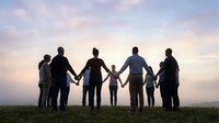 Large multigenerational family holding hands in silhouette against sunset sky, unity and togetherness concept for family bonding and connection.