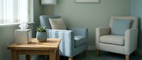 Modern minimalist living room interior with comfortable gray armchairs, wooden coffee table and soft natural lighting for home decor inspiration.
