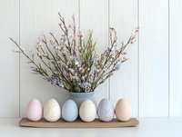 Pastel Easter eggs and spring blossoms arranged on wooden shelf against white wooden wall, creating serene holiday decoration with delicate flowers.