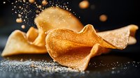 Crispy wavy fortune cookie pieces with powdered sugar falling in dramatic lighting against dark background, macro food photography for restaurant menu design.