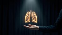 Human hand holding glowing lungs anatomy model in dark background with light beam for medical healthcare and respiratory system concept.