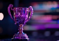 Shiny trophy cup illuminated by vibrant purple and blue neon lights against dark background with bokeh effect, creating dramatic competitive sports atmosphere.