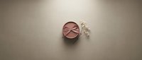 Luxury pink cosmetic powder compact with pearls on neutral background for beauty and makeup advertising campaigns.