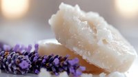 Raw organic shea butter chunks with fresh lavender flowers on blurred background. Natural skincare and aromatherapy ingredients for cosmetic products.