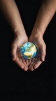 Male hands with medium skin tone holding glowing Earth globe against black background. Concept for environmental protection, sustainability, global responsibility, and conservation efforts.