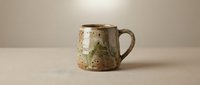 Rustic ceramic mug with speckled glaze and earthy tones, featuring organic texture and handcrafted appeal. Suitable for product photography, home decor, and tableware design.