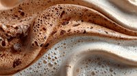 Rich chocolate and vanilla cream swirls create luxurious flowing waves with delicate foam bubbles for dessert and beverage marketing applications.