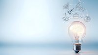 Glowing light bulb with business icons representing innovation, creativity and entrepreneurial ideas for startup success and financial growth strategies.