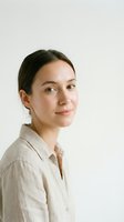 Young professional woman in beige linen shirt smiling confidently at camera against neutral background for business and lifestyle content.