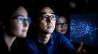 Young Asian professionals analyzing digital data visualization on screen in dark office environment, blue technology glow illuminates focused expressions.
