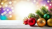 Festive Christmas ornaments and pine branches on white wooden surface against colorful bokeh background.