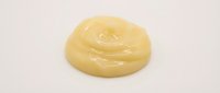 Creamy yellow cosmetic or skincare product swirl isolated on white background, ready for packaging design and beauty marketing materials.