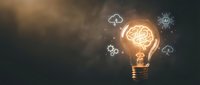 Glowing light bulb with brain inside surrounded by technology icons representing artificial intelligence, innovation and creative thinking concepts.