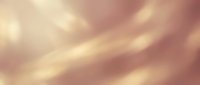Soft blurred abstract background with warm golden and pink tones creating dreamy bokeh effect for romantic designs and elegant presentations.