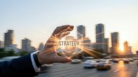 Two hands holding glowing strategy sphere with cityscape and traffic at sunset, representing business planning, corporate vision, and urban development for marketing and financial concepts.