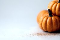 Fresh orange pumpkins on light background with scattered spices, minimalist autumn composition for seasonal food photography and harvest decor.
