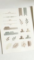 Watercolor design elements set with botanical leaves, decorative dividers, ribbons, clips and paint strokes in neutral earth tones for creative projects.