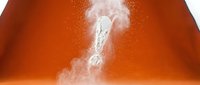 White powder explosion forming question mark shape against vibrant orange gradient background for creative design projects and marketing materials.