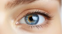 Close-up macro shot of bright blue human eye with long eyelashes and detailed iris pattern showing natural beauty for cosmetic, medical and beauty industry use.