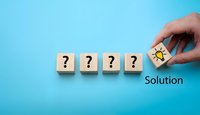 Hand placing lightbulb cube next to question mark blocks showing problem solving and finding solutions on blue background.